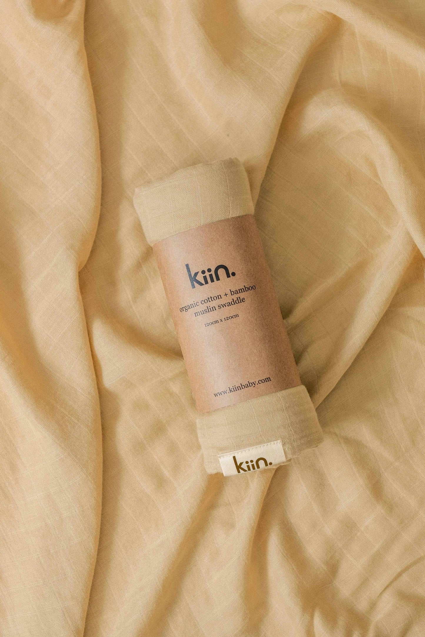 Kiin Organic Swaddle made of soft beige organic cotton and bamboo blend muslin fabric for breathable baby comfort