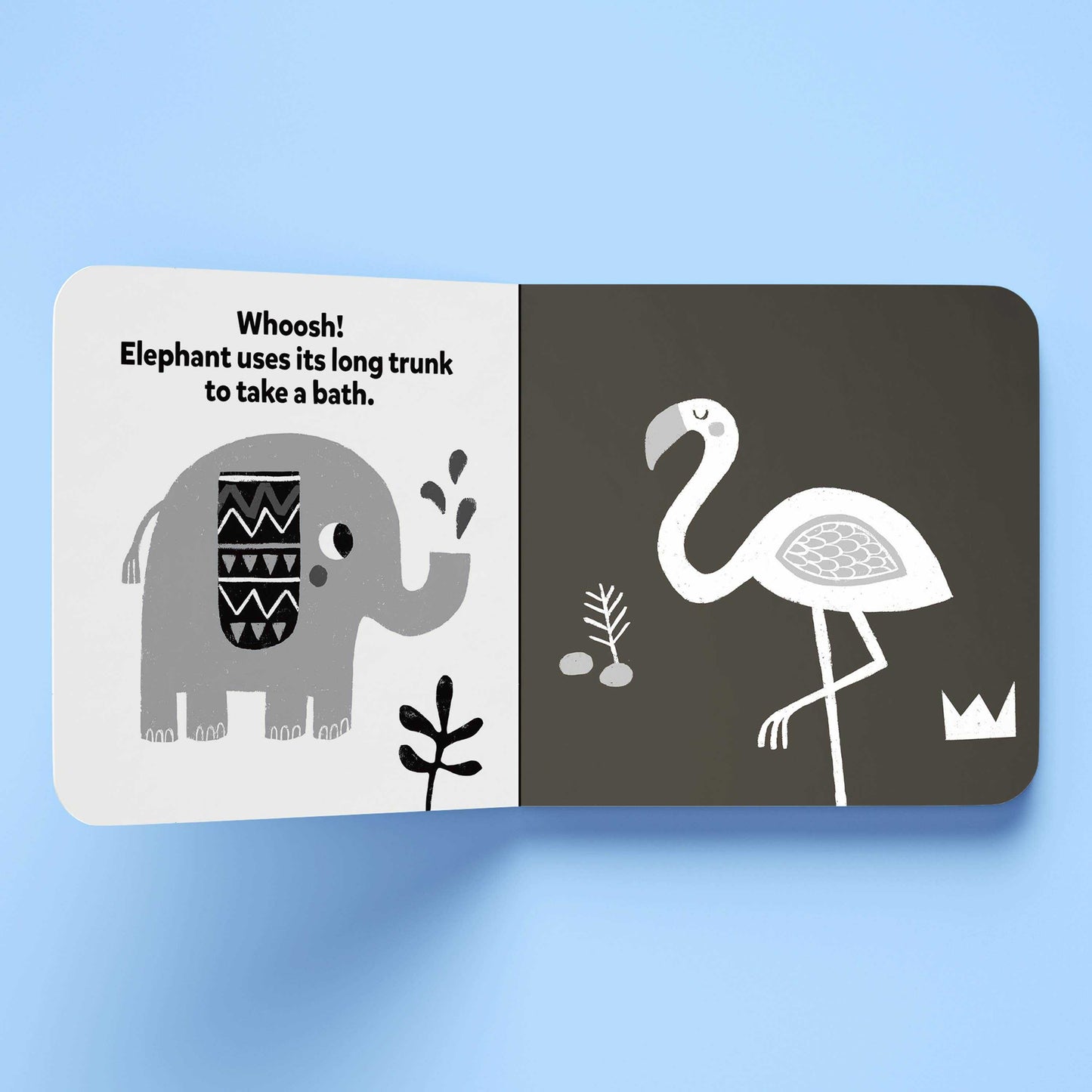 Open high-contrast board book page showing black and white illustrations of an elephant and a flamingo for early cognitive development.