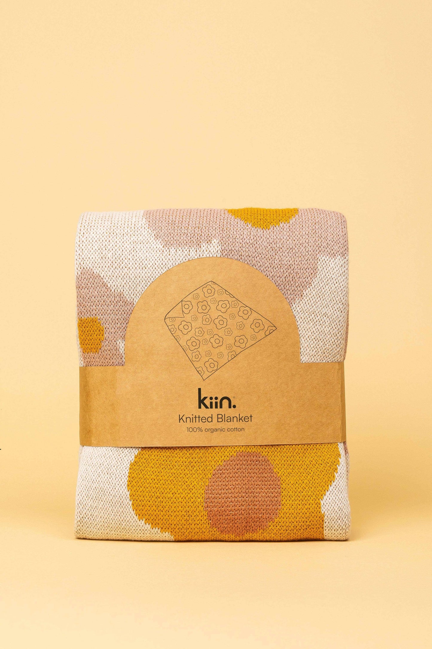 Kiin Organic Cotton Knitted Blanket folded with colorful yarn patterns on beige background