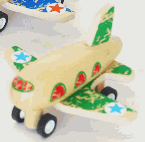 Wooden pull-back plane toy with green and red details and blue star decals on wings and tail