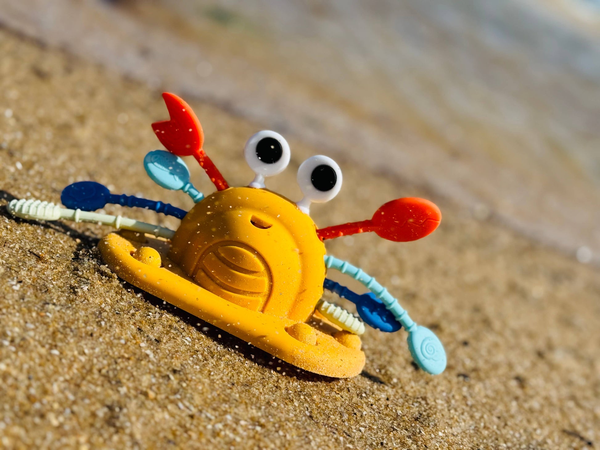 Silicone crab pull string sensory toy for toddlers on sandy beach